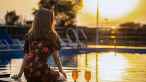 Woman relaxing by pool during beautiful sunset view