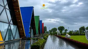 Colorful A-frame cottages at Sunflower Saga surrounded by lush monsoon landscape and cloudy skies